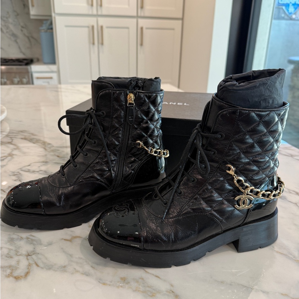 Chanel 39.5 black shiny/patent calfskin quilt combat boot with gold charm chain.